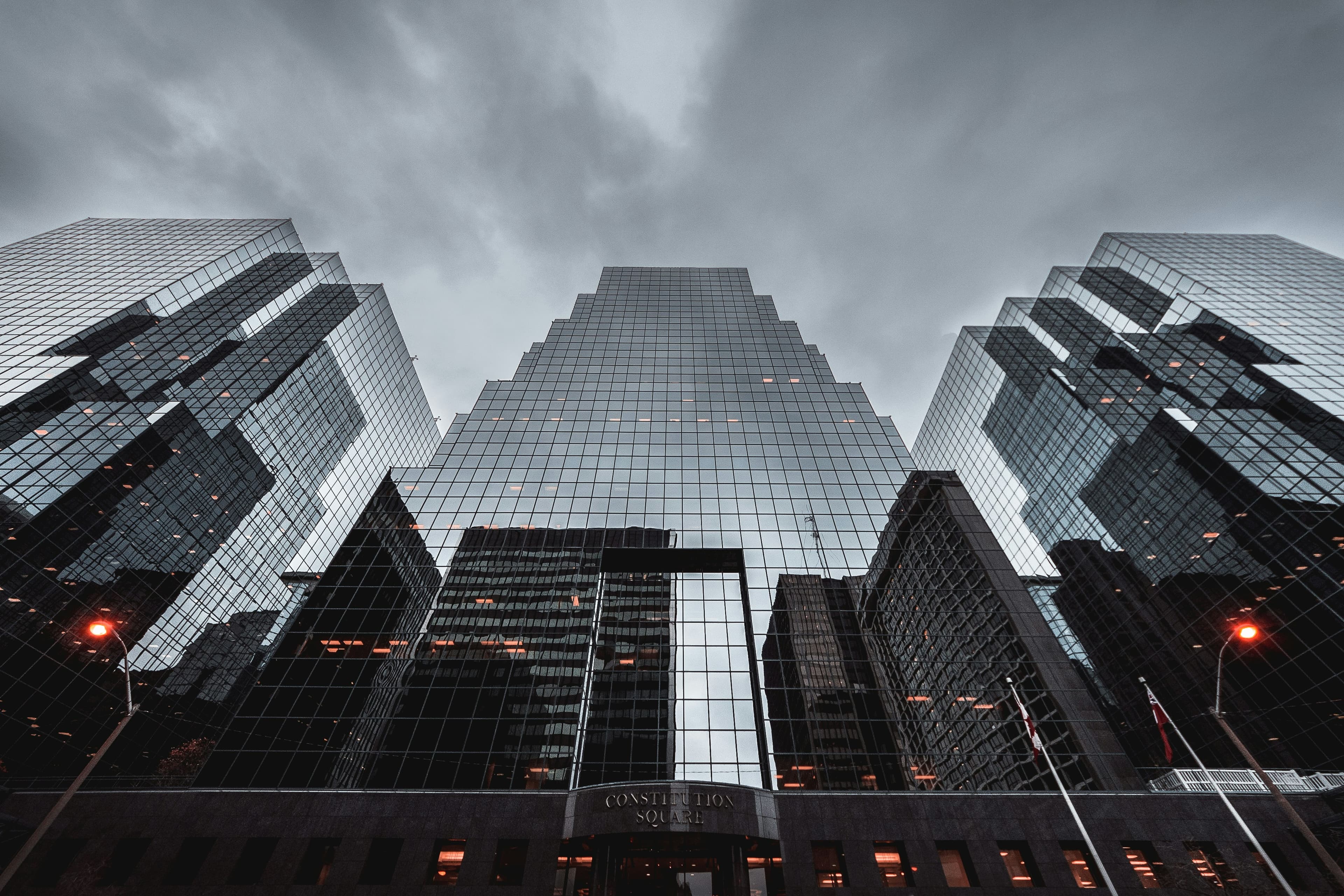Reflective glass office architecture beneath a moody sky