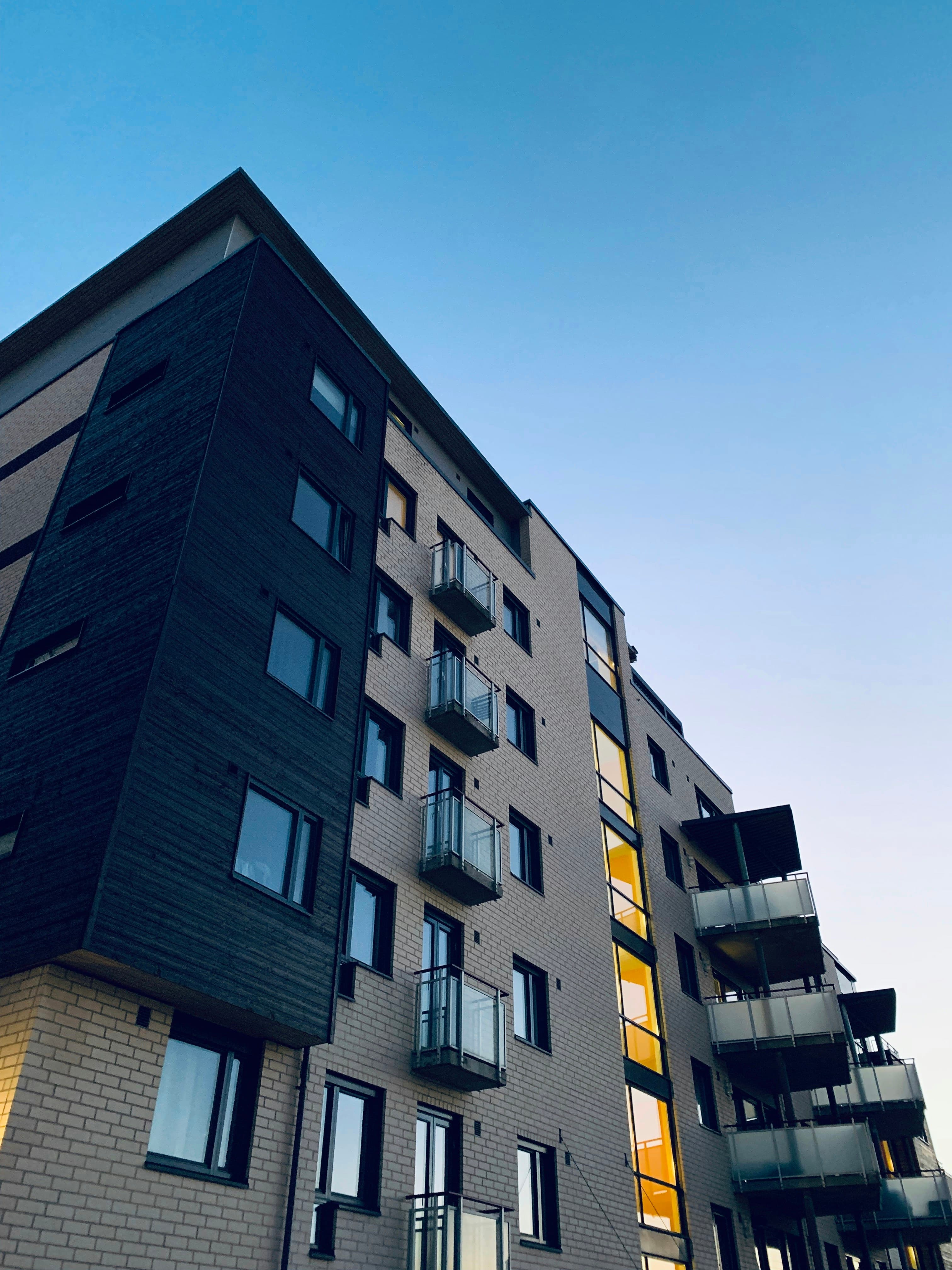 Contemporary residential building with balconies rising against a clear evening sky